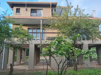 a large house with trees in front of it at Penthouse At Kruger Safari Lodge in Marloth Park