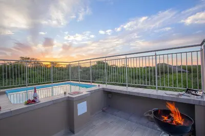a balcony with a pool and a fire pit at Penthouse At Kruger Safari Lodge in Marloth Park