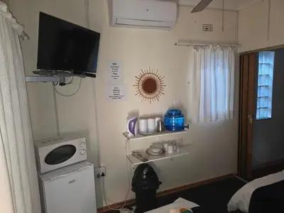 a small room with a television on the wall at Lekker Breek Gastehuis in Groblersdal