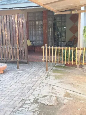 a wooden fence in front of a house at Lekker Breek Gastehuis in Groblersdal