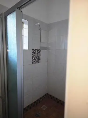 a shower with a glass door in a bathroom at Lekker Breek Gastehuis in Groblersdal