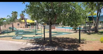 a park with a tree and a playground at Unit 35 Pendleberry grove holidays in Bela-Bela