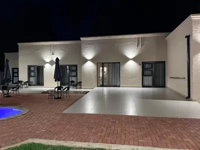 a large white building with chairs and tables at night at Cathy & P Guesthouse in Hartbeespoort