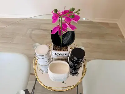 a table with a vase with flowers and cameras on it at Cathy & P Guesthouse in Hartbeespoort