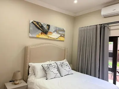 a bedroom with a bed with two pillows at Cathy & P Guesthouse in Hartbeespoort