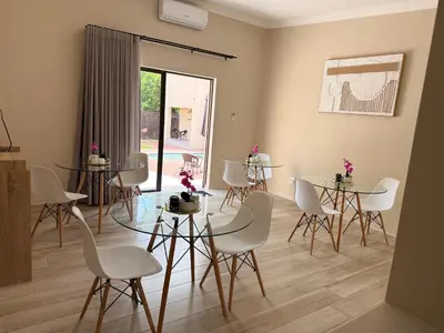 a room with white chairs and tables and a window at Cathy & P Guesthouse in Hartbeespoort
