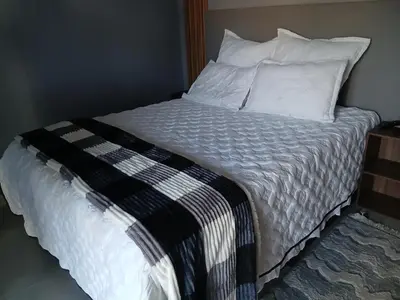 an unmade bed with white sheets and pillows at Moonlight Guest House Lethabong in Vaalkop Dam