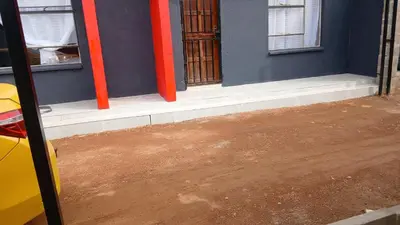 a blue building with red poles on the side of it at Moonlight Guest House Lethabong in Vaalkop Dam