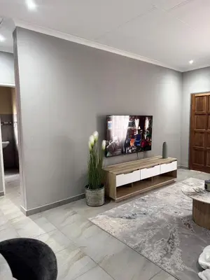 a living room with a flat screen tv on a wall at Cozzy home in Polokwane