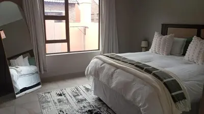 a bedroom with a large bed and a window at Cozzy home in Polokwane