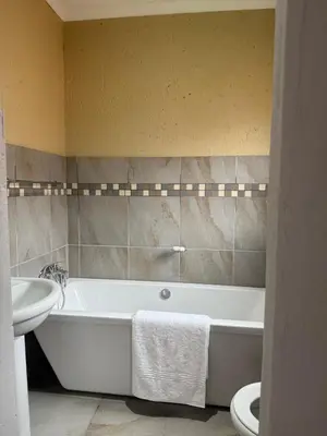 a bathroom with a tub and a sink and a toilet at Cozzy home in Polokwane
