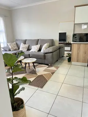 a living room with a couch and a table at Apartment at The Blyde in Pretoria