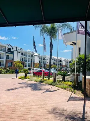 a person walking down a sidewalk in front of a building at Apartment at The Blyde in Pretoria