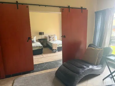 a living room with a sliding glass door with a couch at The Country Hole Haven in Centurion