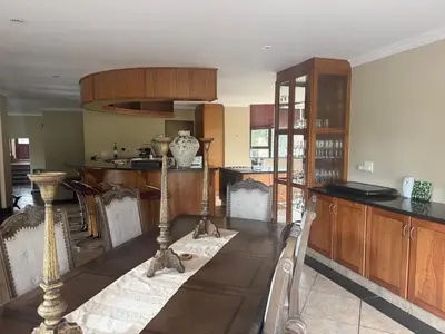 a kitchen with wooden cabinets and a table with chairs at The Country Hole Haven in Centurion