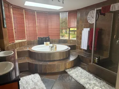 a large bathroom with a tub and a shower at The Country Hole Haven in Centurion