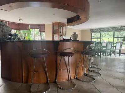 a bar with a row of stools in a kitchen at The Country Hole Haven in Centurion