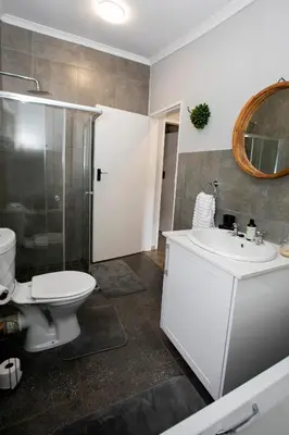 a bathroom with a toilet and a sink and a shower at Buchan's Corner Unit 2 in Hartbeespoort