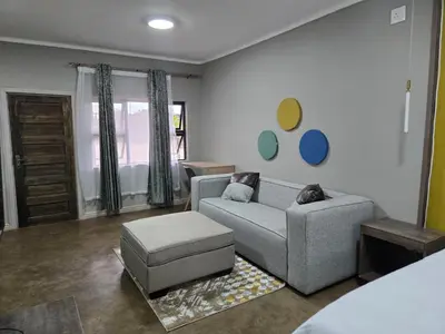 a living room with a couch and a chair at Cuse Boutique Lodge and Conference in Polokwane