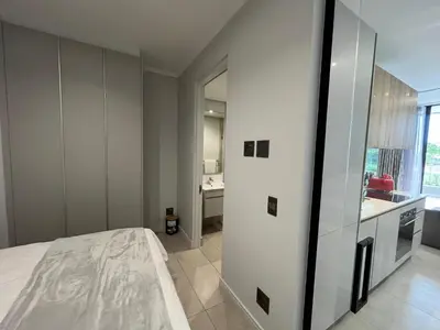 a bedroom with a white bed and a bathroom at The S-teemed at Ellipse in Midrand
