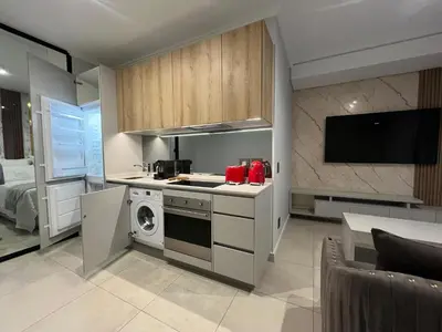 a kitchen with a stove and a microwave at The S-teemed at Ellipse in Midrand