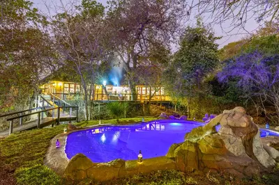 a large swimming pool in a park at night at Kusudalweni Safari Lodge and Spa in Guernsey Nature Reserve
