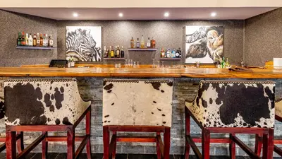 a bar with two chairs in front of a counter at Kusudalweni Safari Lodge and Spa in Guernsey Nature Reserve