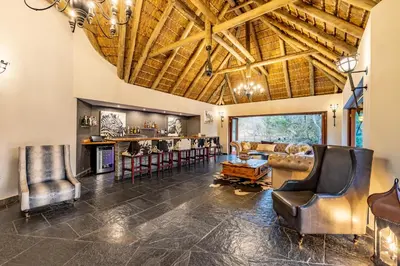 a living room with leather chairs and a bar at Kusudalweni Safari Lodge and Spa in Guernsey Nature Reserve