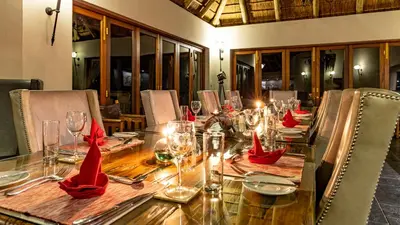a long table with red napkins and glasses on it at Kusudalweni Safari Lodge and Spa in Guernsey Nature Reserve