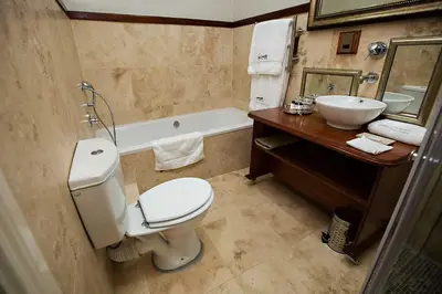 a bathroom with a toilet and a sink and a tub at Mavuta Boutique Apartments in Polokwane