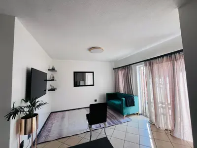 a living room with a green couch and a window at Rhegimel 9 in Midrand