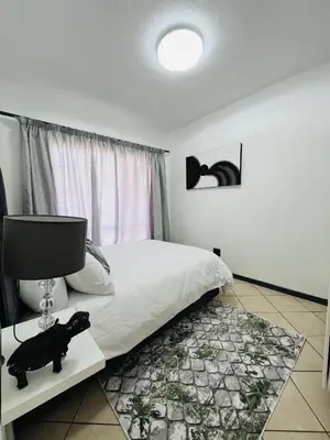 a bedroom with a bed and a computer on a table at Rhegimel 9 in Midrand