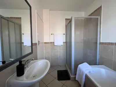 a bathroom with a sink and a shower and a tub at Rhegimel 9 in Midrand
