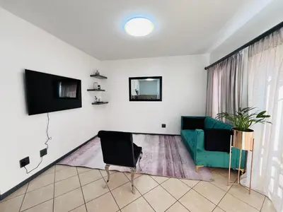 a living room with a couch and a tv at Rhegimel 9 in Midrand