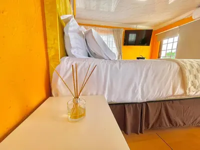 a room with a bed and a table with a vase on it at Spacious Entire place with Balcony in Kempton Park
