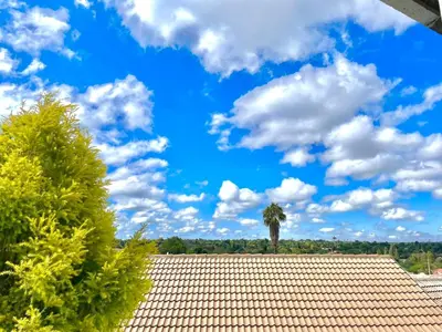 a tile roof with a palm tree in the background at Spacious Entire place with Balcony in Kempton Park