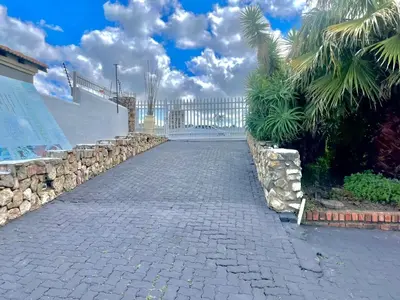 a cobblestone street with a white fence and palm trees at Spacious Entire place with Balcony in Kempton Park
