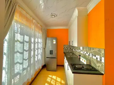 a kitchen with orange walls and a refrigerator at Spacious Entire place with Balcony in Kempton Park