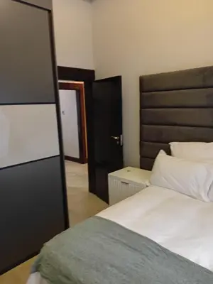 a bedroom with a white bed and a mirror at Big Mo Bev and Grill in Middelburg