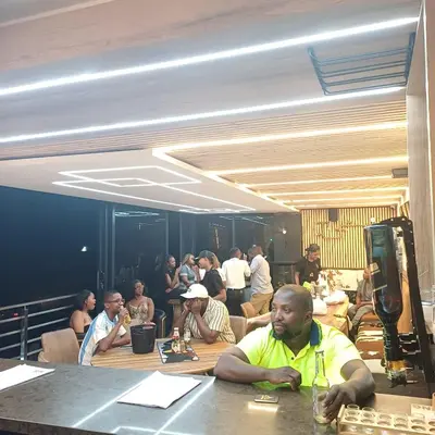 a group of people sitting at tables in a room at Big Mo Bev and Grill in Middelburg
