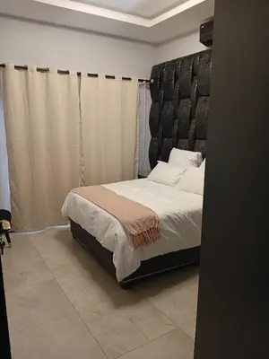 a bedroom with a bed with a large headboard at Big Mo Bev and Grill in Middelburg