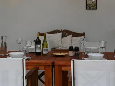 a wooden table with wine bottles and glasses on it at Memory Makers Bush Lodge in Hoedspruit