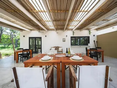 a dining room with a wooden table and chairs at Memory Makers Bush Lodge in Hoedspruit