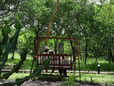 a man sitting on a bench in a park at Memory Makers Bush Lodge in Hoedspruit