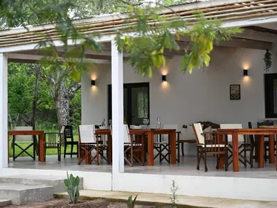 a patio with wooden tables and chairs on it at Memory Makers Bush Lodge in Hoedspruit