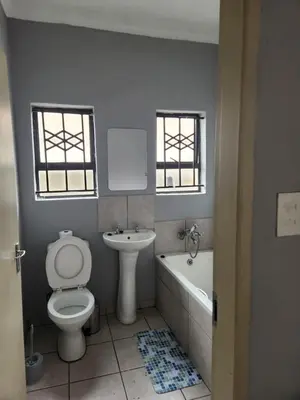 a bathroom with a toilet and a tub and a sink at Cozy Guest House in Ermelo