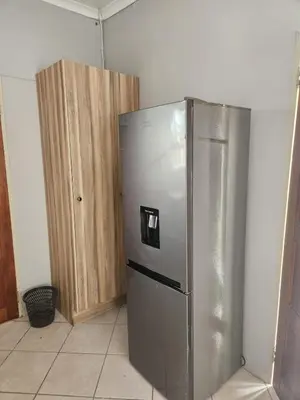 a kitchen with a stainless steel refrigerator and wooden cabinets at Cozy Guest House in Ermelo