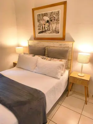 a bedroom with a bed with a picture on the wall at Peaceful Private Secure Bachelor Flat in Pretoria