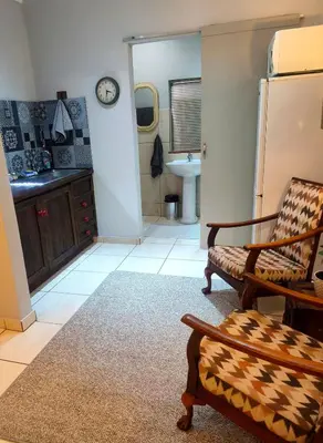 a living room with a chair and a sink at Peaceful Private Secure Bachelor Flat in Pretoria