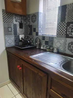 a kitchen with a wooden counter top and a sink at Peaceful Private Secure Bachelor Flat in Pretoria
